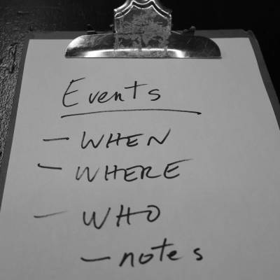 A handwritten checklist and information for events on a clipboard