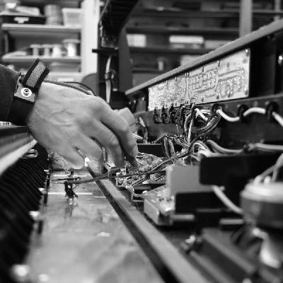 Someone soldering broken equipment on a neat repair bench